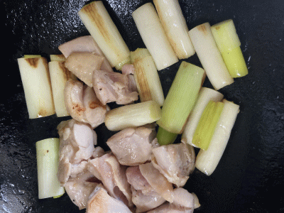 鍋で鶏肉とネギを炒める